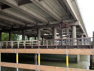 Foto der Unterseite einer Brücke mit Holzgeländer