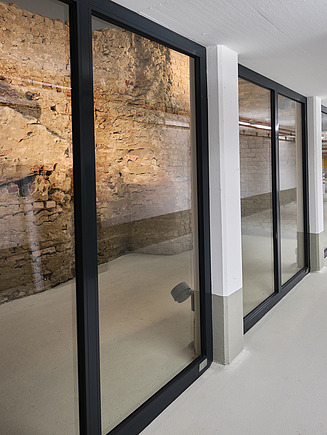 Foto einer Stadtmauer hinter Schutzglas