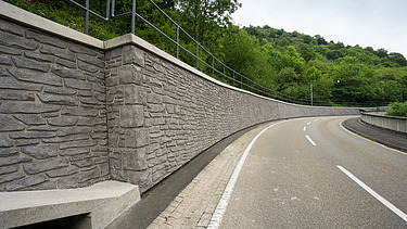 Foto von einer Reliefwand in Natursteinoptik und einer Straße