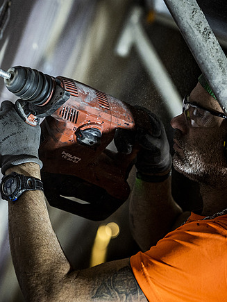 Foto von einem Mann mit einer Bohrmaschine in der Hand