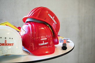 Foto von mehreren Helmen auf einem Tisch mit Torkret Logo