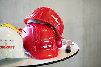 Foto von mehreren Helmen auf einem Tisch mit Torkret Logo