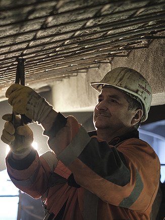 Foto von einer Person am Biegen von Bewehrung