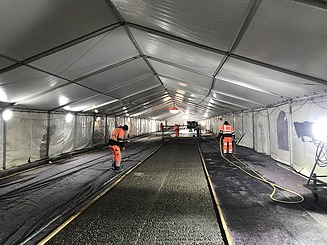 Foto von Personen mit Warnweste in einem Zelt