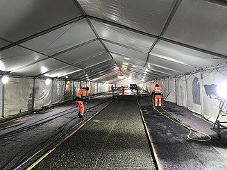 Foto von Personen mit Warnweste in einem Zelt